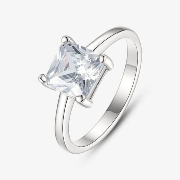 Silver engagement ring with a square-cut, clear gemstone set in a prong setting, displayed on a plain white background.