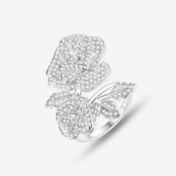 A silver ring with two intricately designed rose shapes, encrusted with small sparkling diamonds, and leaf details on a white background.