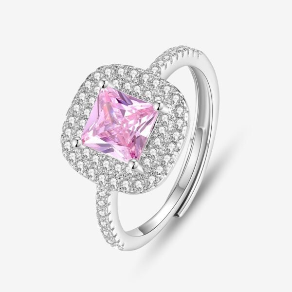 A silver ring featuring a square-cut pink gemstone at the center, surrounded by a double halo of small clear diamonds. The band is encrusted with more clear diamonds, highlighting its elegant design.