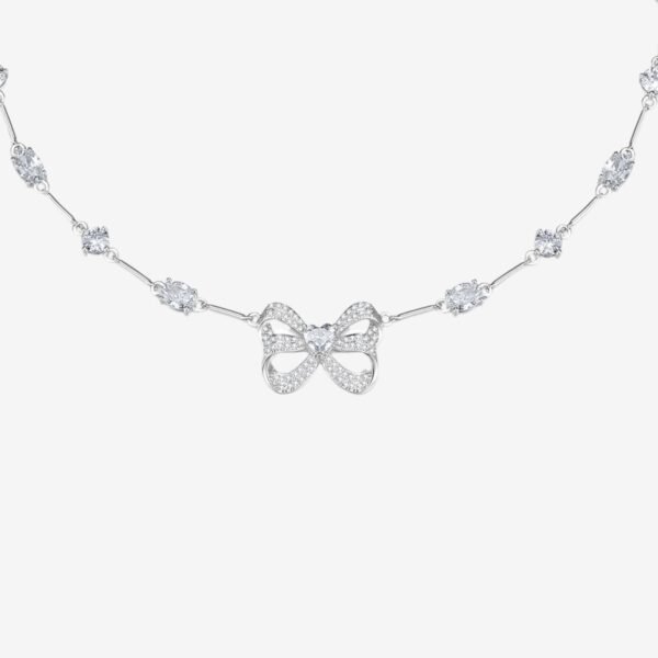 A delicate silver necklace featuring a bow-shaped centerpiece adorned with small sparkling stones. The chain is accented with evenly spaced clusters of glittering gems, set against a plain white background.