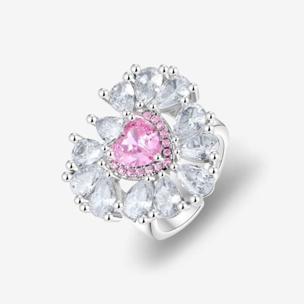 A luxurious ring featuring a central heart-shaped pink gem surrounded by smaller pear-shaped clear stones in a floral arrangement, set in a shiny silver band on a white background.