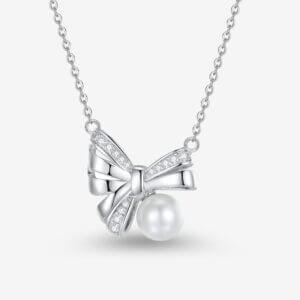 Silver necklace with a bow-shaped pendant adorned with small crystals, featuring a pearl hanging beneath the bow. The chain is delicate, and the design is elegant and sophisticated.