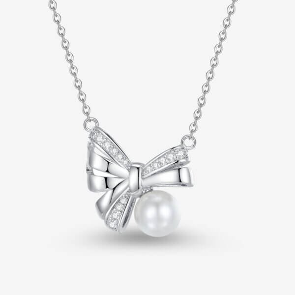 Silver necklace with a bow-shaped pendant adorned with small crystals, featuring a pearl hanging beneath the bow. The chain is delicate, and the design is elegant and sophisticated.