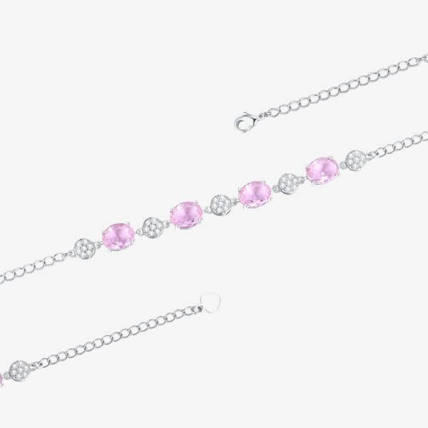 A delicate silver bracelet with round pink gemstones and clear stones. The bracelet features a lobster clasp closure and an adjustable chain for sizing. The design is elegant and minimalistic, suitable for formal or casual wear.