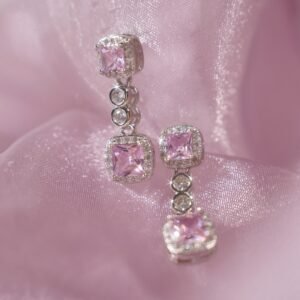 Elegant drop earrings featuring square pink gemstones surrounded by small clear stones, connected by three circular clear stones. Set in a silver or platinum finish, displayed on a plain white background.