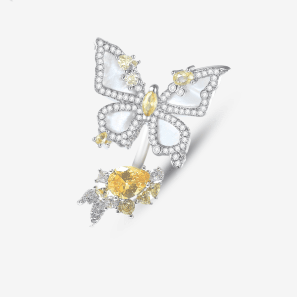 An ornate butterfly-shaped ring with sparkling white and yellow gemstones, featuring intricate wings and a large yellow gemstone at the center, set against a plain white background.