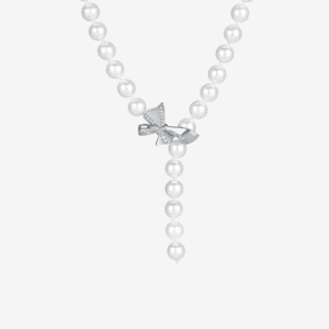 A pearl necklace with a string of round pearls forms a Y-shape, centered by a silver bow adorned with small, clear gemstones. The necklace is displayed on a plain white background.