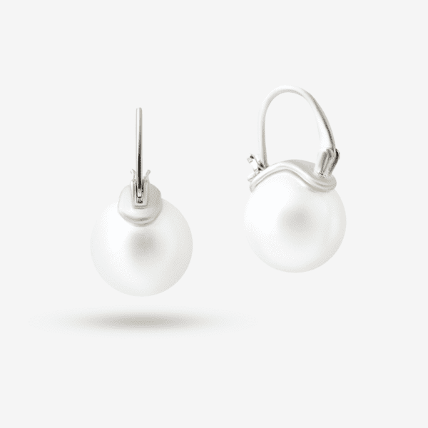 A pair of elegant silver earrings featuring round pearl pendants. The design includes a smooth, curved silver setting that clasps the pearls, set against a plain white background.
