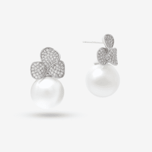 Elegant earrings featuring large, round pearls and silver floral designs adorned with small, sparkling crystals. The background is plain white.