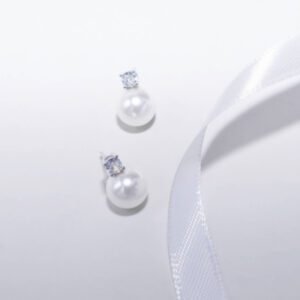A pair of elegant pearl earrings with diamond studs on a white background.