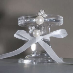 Elegant earrings featuring large, round pearls and silver floral designs adorned with small, sparkling crystals. The background is plain white.